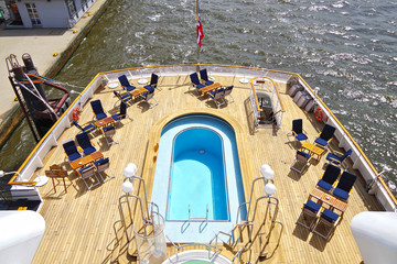 Bequeme Sonnenliegen Liegen auf hölzernem Pool Deck von Luxus Kreuzfahrtschiff Yacht Yacht...