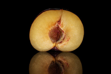 One half of fresh red plum isolated on black glass