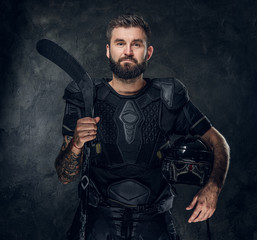 Portrait of middle aged handsome man with hockey stick and uniform.