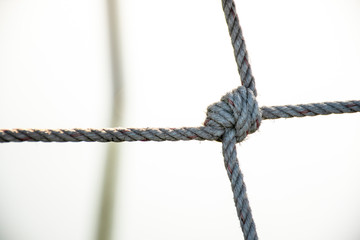 Mesh rope, sea rope fence, Tight knot is used for safety barrier net and fishing net. Blurry background, abstract.