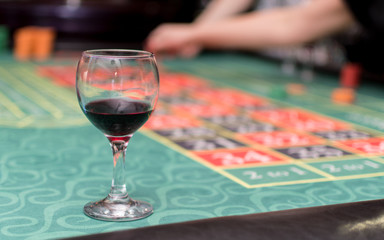 A glass of red wine on the table of an underground casino.