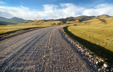 Fototapeta na wymiar Unpaved road and Tian Shan mountains in Kyrgyzstan