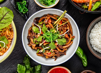 Asian udon noodles with spicy soy sauce and chicken pieces, top view