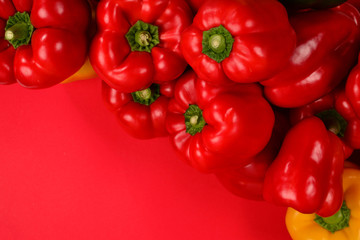 Fresh red, yelow, green bell pepper on a red background.