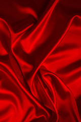 Red silk or satin luxury fabric texture can use as abstract background. Top view.