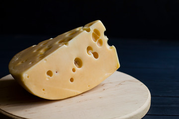 cheese with holes on a wooden cutting board  B