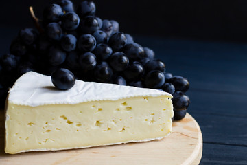 cheese, grapes, on a wooden board