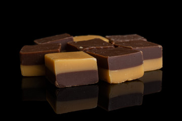 Group of eight whole sweet brown caramel chocolate candy isolated on black glass