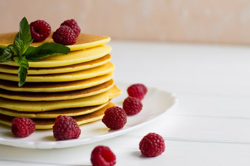 pancakes with raspberries on a white plate