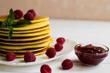 pancakes with raspberries on a white plate