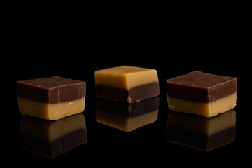 Group of three whole sweet brown caramel chocolate candy isolated on black glass