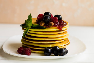 pancakes with raspberries on a white plate
