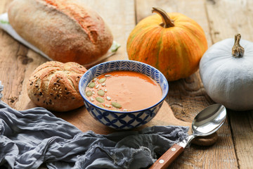 Vegetarian autumn pumpkin cream soup with seeds. Seasonal autumn food - pumpkin soup with thyme. Pumpkin soup with herbs, cream, breadcrumbs and parmesan, served in a bowl, top view. Place for text