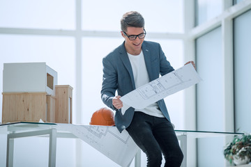 smiling architect reading a drawing of a new project.