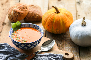 Vegetarian autumn pumpkin cream soup with seeds. Seasonal autumn food - pumpkin soup with thyme. Pumpkin soup with herbs, cream, breadcrumbs and parmesan, served in a bowl, top view. Place for text