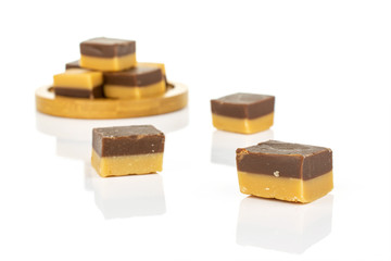 Group of eight whole sweet brown caramel chocolate candy on bamboo coaster isolated on white background