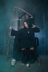 young very angry man with a caucasian face is dressed in a black robe and leather big boots and...