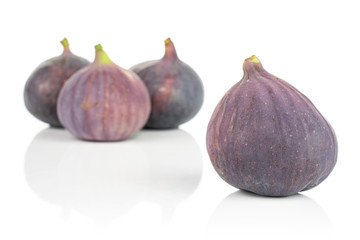 Group of four whole fresh purple fig isolated on white background