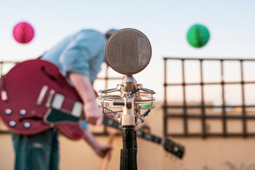 Detail of a vintage old microphone isolated on a festival background. Live music concept. Intimate concert abut to start. Musicians rehearsing and testing sound conditions before performing.
