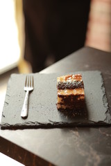 Showcase with cakes and sweets. Cupcakes and cupcakes on a showcase in the refrigerator. A slice of cake with a cup of coffee in a cafe. Cake snickers and strawberry cake. Dessert in a restaurant