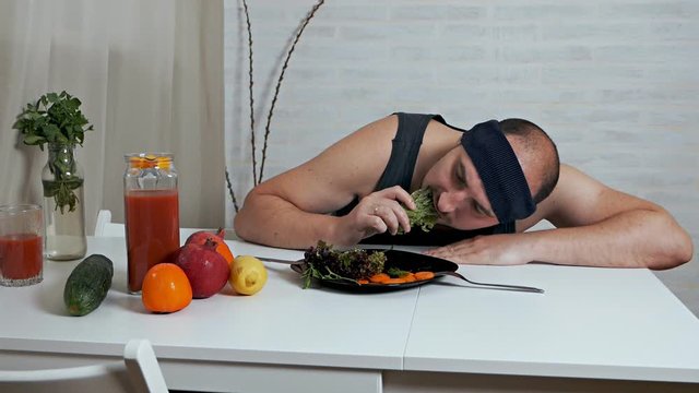 A bald fat vegetarian disgustingly eats salad. Proper nutrition, healthy lifestyle