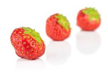 Group of three whole fresh red strawberry placed diagonally isolated on white background