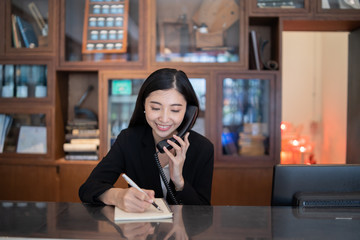Welcome to the hotel,Happy young Asian woman hotel receptionist worker smiling standing,she taking ...