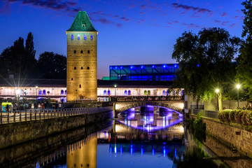 Fototapeta na wymiar The Ponts Couverts and Vauban Dam on the river Ill in the Petite France quarter in Strasbourg, France, reflecting in the still waters at nightfall.