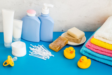 Baby bathroom cosmetics near pacifier and rubber duck on blue background