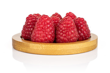 Lot of whole fresh red raspberry on bamboo coaster isolated on white background