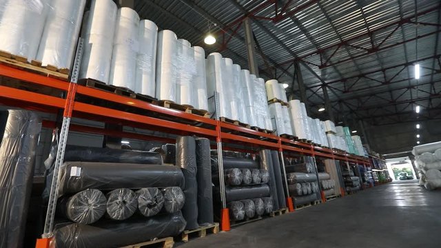 Large clean light warehouse in a factory, warehouse with rolls of products
