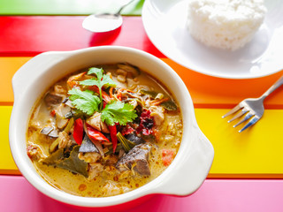 Traditional famous thai food, Chicken with coconut milk and galangal soup in white ceramic dish on colorful table