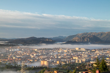 Fototapeta na wymiar Oviedo city aerial panoramic sunrise foggy view from a mountain viewpoint near Oviedo, Spain