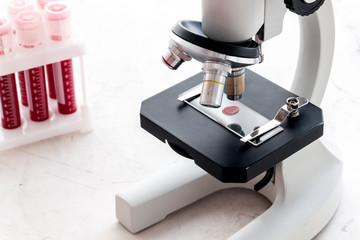 Blood drop under microscope on white background