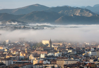 Obraz premium Oviedo city aerial panoramic sunrise foggy view from a mountain viewpoint near Oviedo, Spain