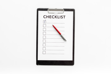 Checklist and pen on white background top view copy space