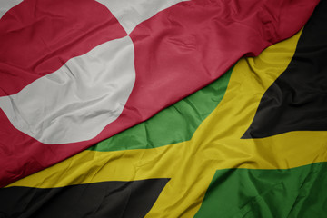 waving colorful flag of jamaica and national flag of greenland.