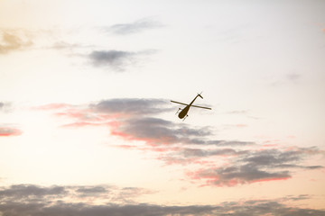 Helicopter against the morning sky, some scattered clouds, emergency mission in progress; aerial vehicle concept.