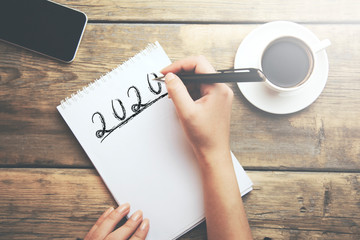 woman hand 2020 text on paper  on desk