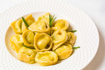 Homemade tortelloni - italian pasta stuffed with ricotta and spinach. Light background.