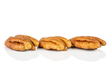 Group of three whole dry brown pecan nut isolated on white background