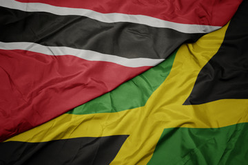 waving colorful flag of jamaica and national flag of trinidad and tobago.