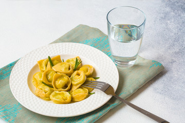 Homemade tortelloni - italian pasta stuffed with ricotta and spinach. Light background.