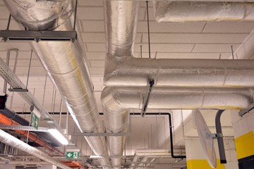 Water pipes and cable trays run under ceiling of a building