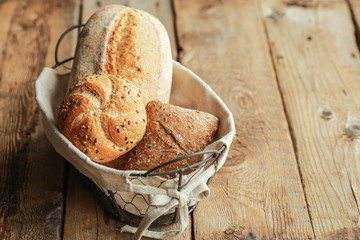 Bread in a basket on a black background. Assorted baking in a metal basket. Place for recipe and...