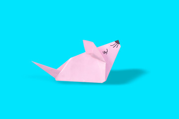 Origami pink paper mouse on a light blue background. Symbol of 2020