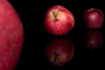 Group of three whole fresh apple red delicious isolated on black glass