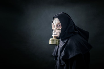 Man in a gas mask and hooded cloak. Environment pollution. 