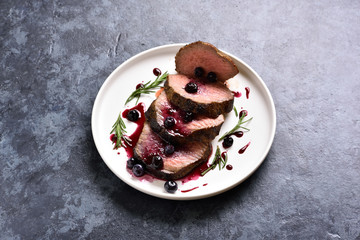 Sliced grilled beef with blueberry sauce