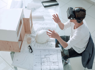 architect in virtual reality helmet sitting at the table